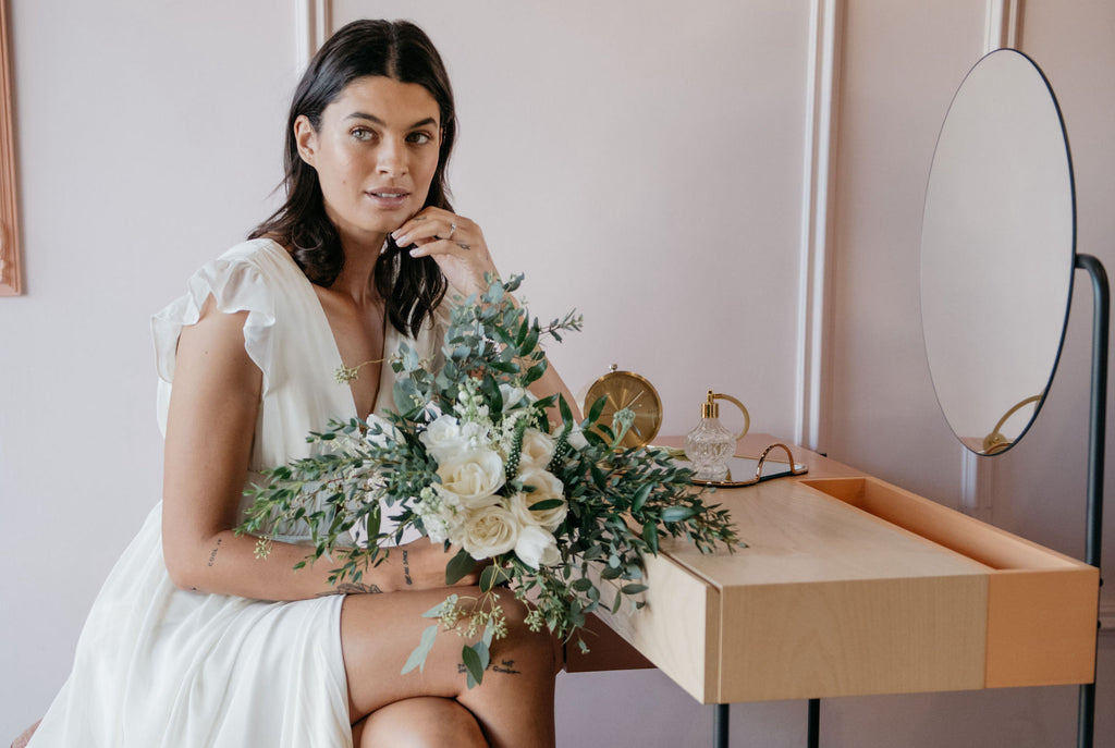 Bride sitting with wedding flowers